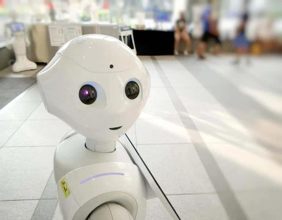 A small white humanoid robot in a shopping center