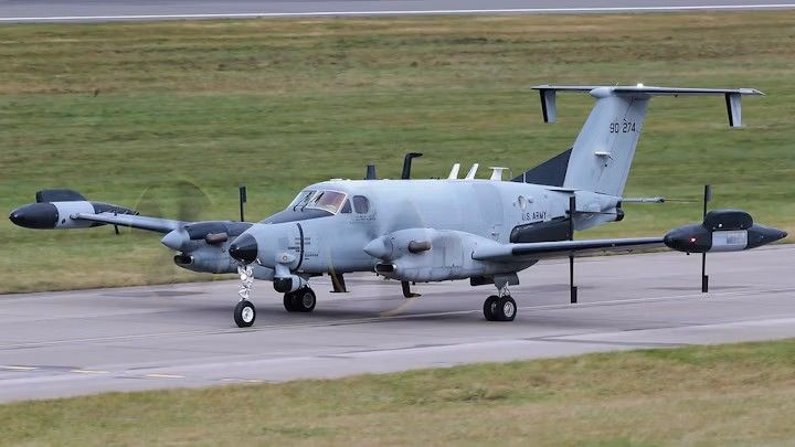 US Army RC-12 reconnaissance aircraft, twin turboprop with sensor pods on the wingtips and fuselage, serial 90-274, taxiing on a runway
