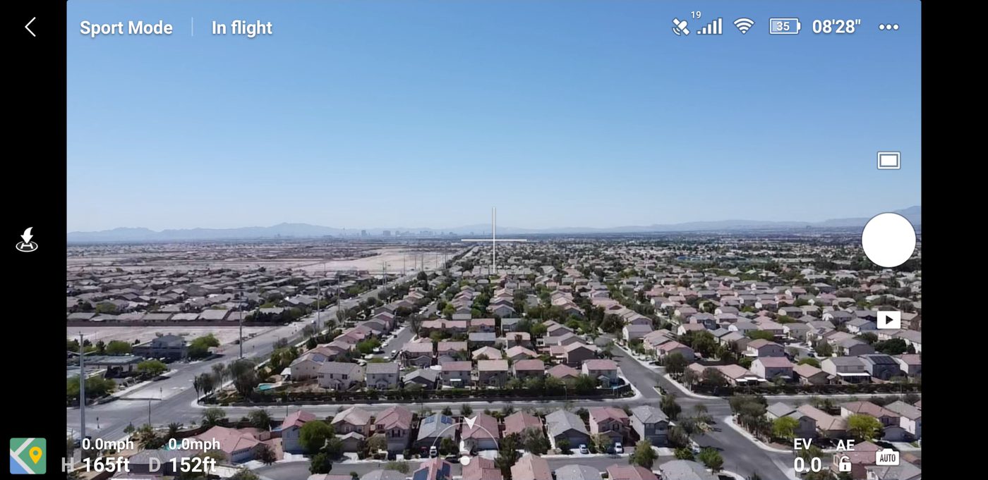 DJI Fly app in flight over a suburb, white battery indicator at 35 percent, 8 minutes 28 seconds remaining