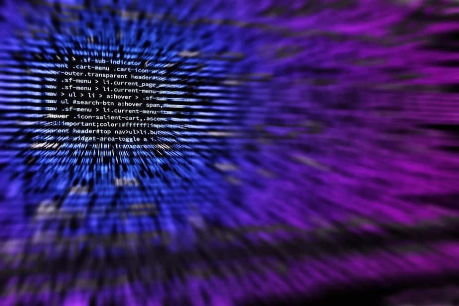 Abstract digital artwork of white code streaking with motion blur across a blue to magenta gradient