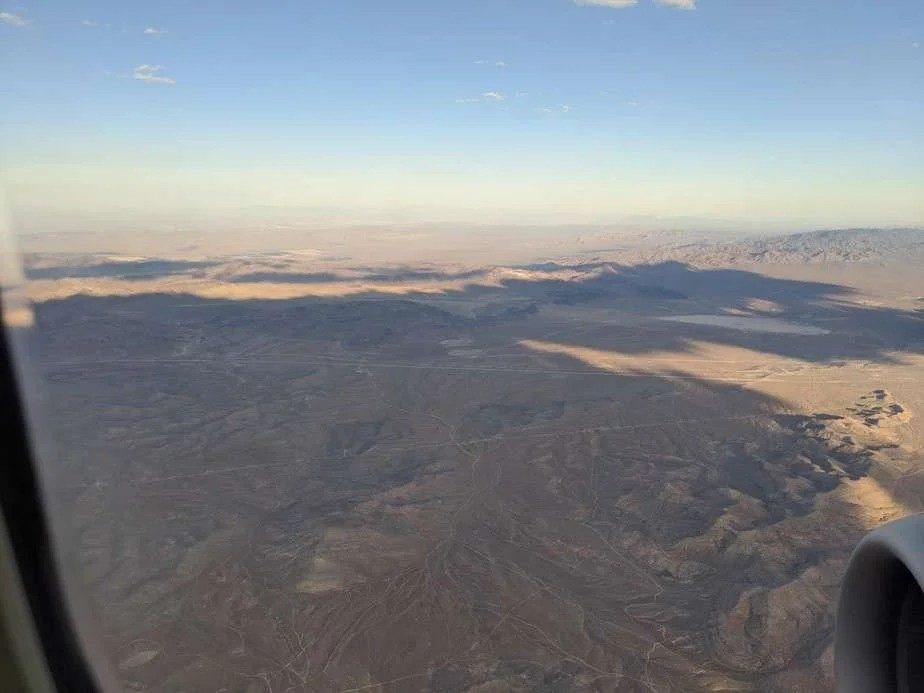 Desert terrain seen from an airliner window at dusk